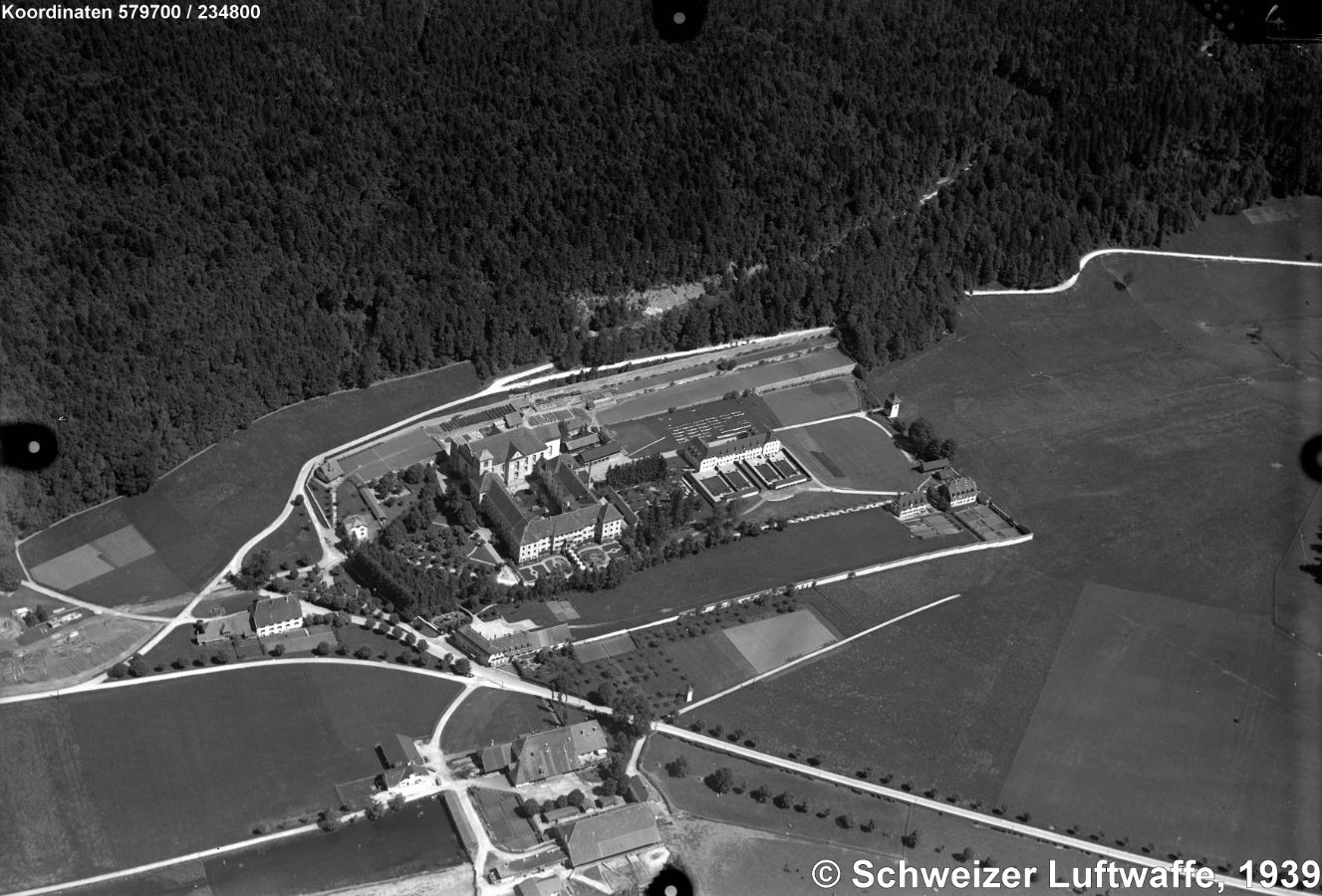 Ehemalige Prämonstratenser - Abtei Bellelay (Gemeinde Saicourt, Position 2'579'535.00, 1'234'838.75), Aufnahme von 1939. Als Abtei um 1141 erstmals erwähnt. Die Blütezeit des Klosters war im 18. Jhd. als Bildungszentrum für Söhne des europäischen Adels. Teilweise Zerstörung des Gebäudekomplexes in der Französischen Revolution. Danach Heil- und Pflegeanstalt, Uhrenfabrik, Brauerei, Glashütte. Heute: psychiatrische Klinik. - Barocke Klosterkirche und Orgel von Joseph Bosshard 1721 restauriert.